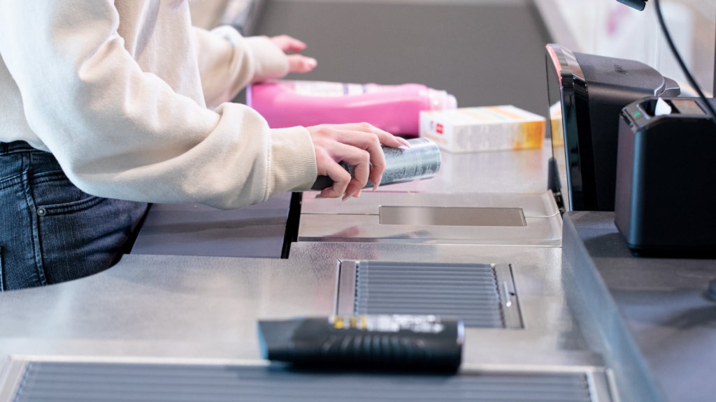 Bild einer Kasse im Supermarkt. Eine Person scannt Produkte über ein Kassensystem mit Warenscanner.